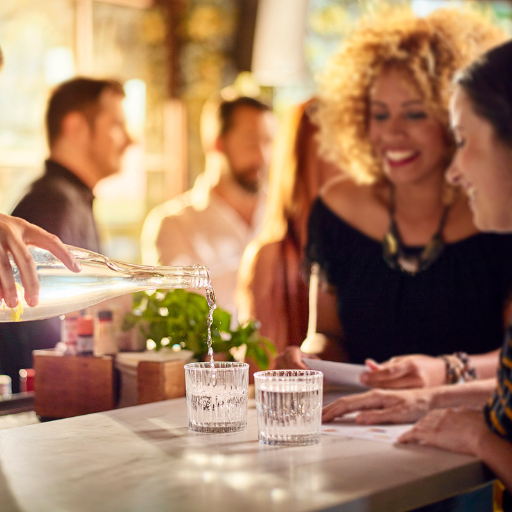 Bartender serving two guests water