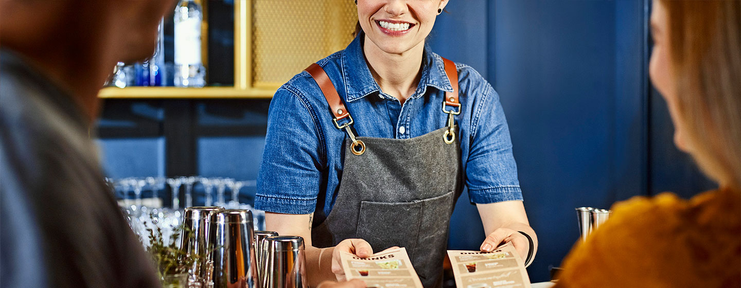 Bartender with two menus for customers