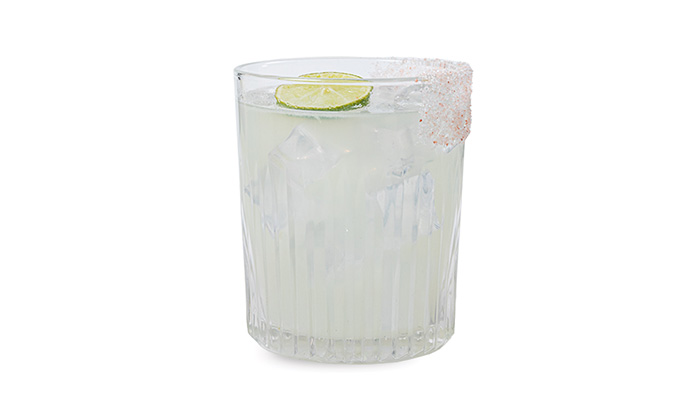 Cocktail in a rocks glass with lime wheel garnish