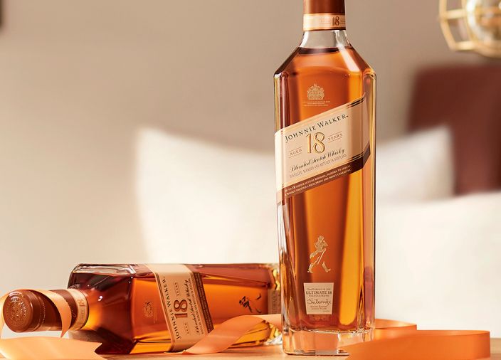 johnnie walker 18 years whisky bottle beside 2 whisky glasses