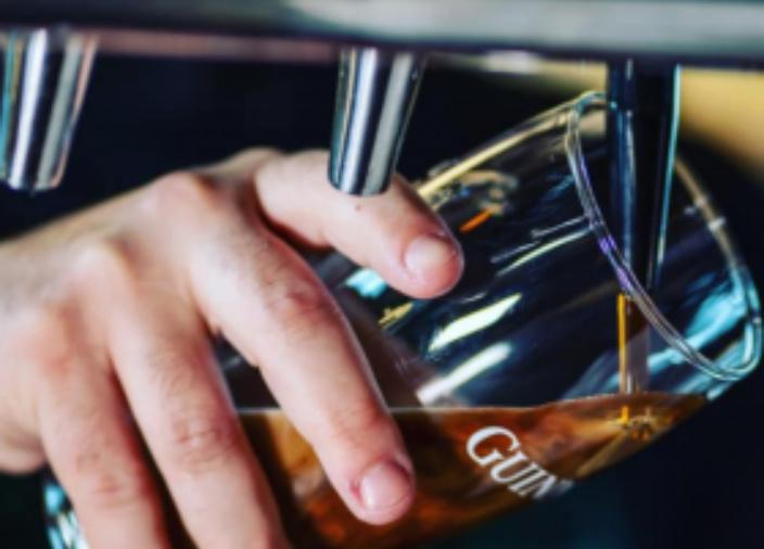 A pint of Guinness being poured at a 45 degree angle. 