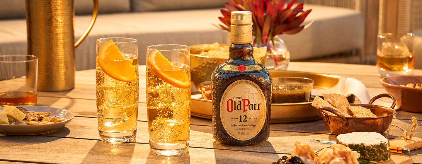 Bottle of Old Parr on table with cocktails