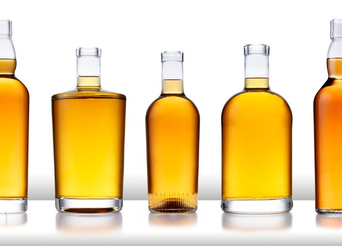 Variedade de garrafas de vidro contendo whisky.