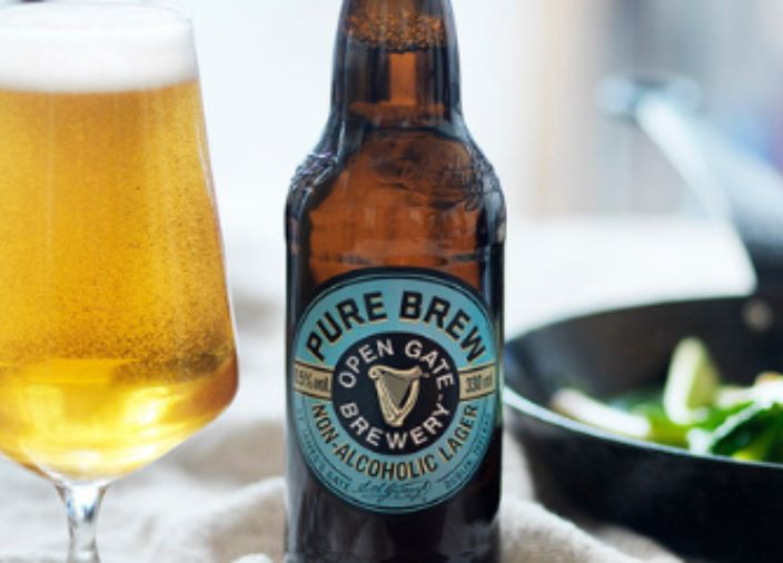 Bottle of Pure Brew open gate non-alcoholic beer sitting next to food and poured