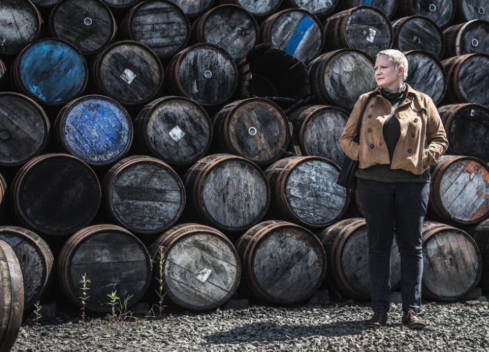 Dr Emma Walker steht vor vielen Whisky Fässern 