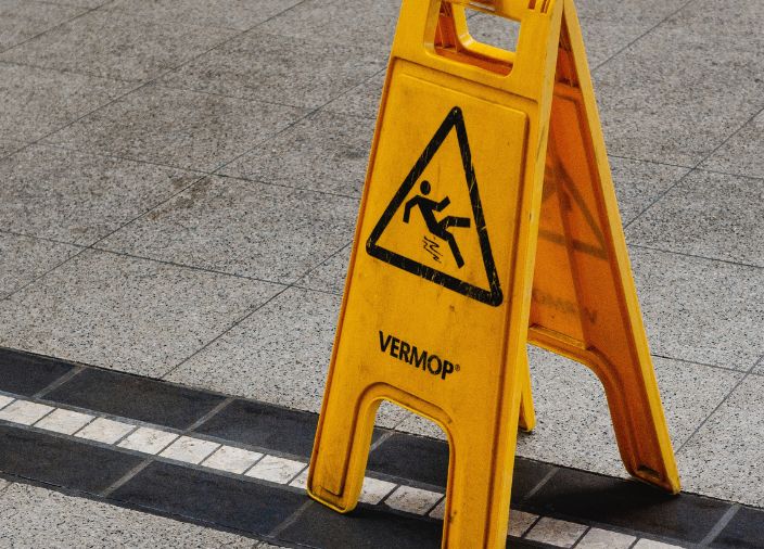 Close up of a wet floor safety sign on a slippery surface.