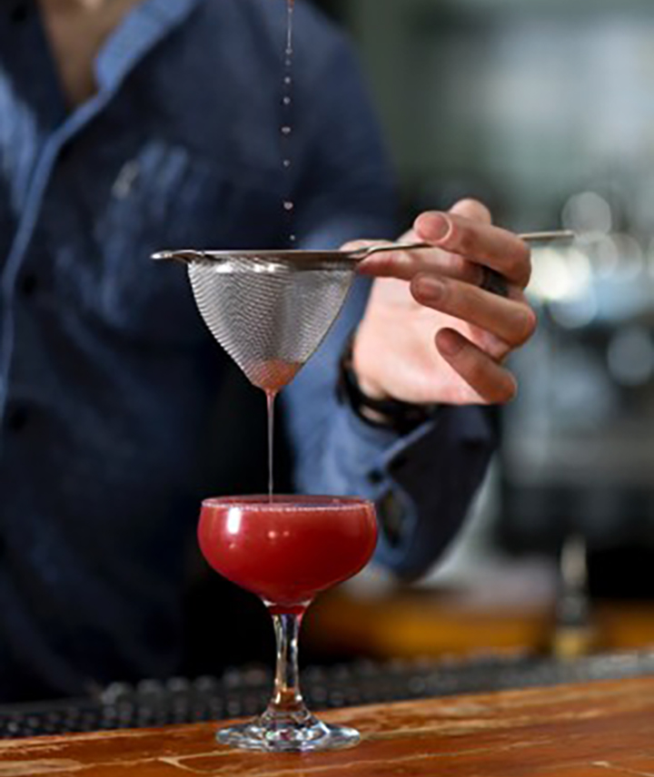 Pouring a cocktail through a fine filter 