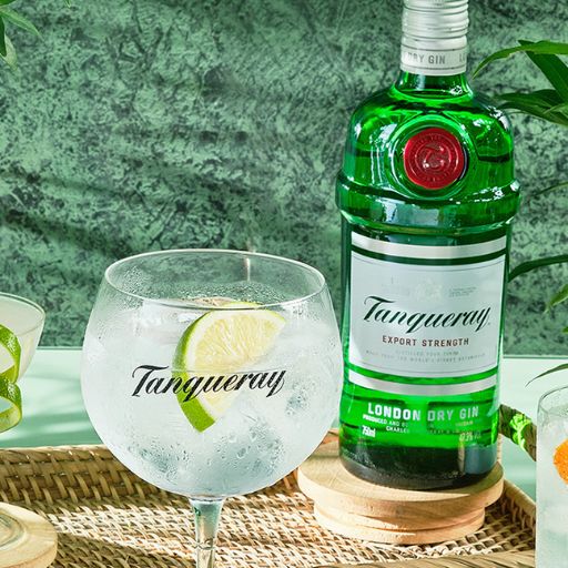 A Gin Spritz in a goblet next to a bottle of Tanqueray London Dry Gin