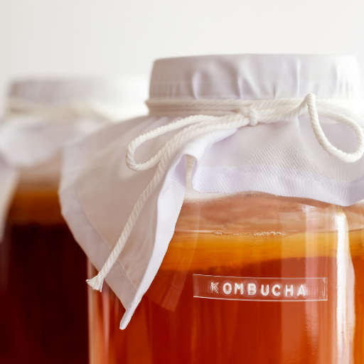 Jars of kombucha with fabric lids