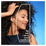 Donna con capelli ricci sorride, evidenziando Per tutti i tipi di cuoio capelluto.