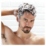 Uomo con capelli insaponati e schiuma