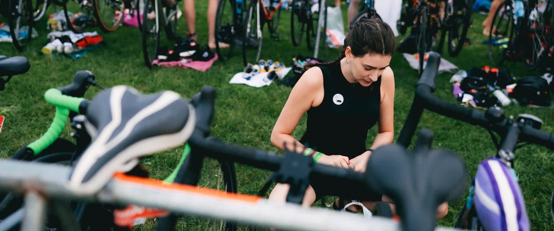 Supertri triathlete in transition zone preparing bike and swim gear for race day