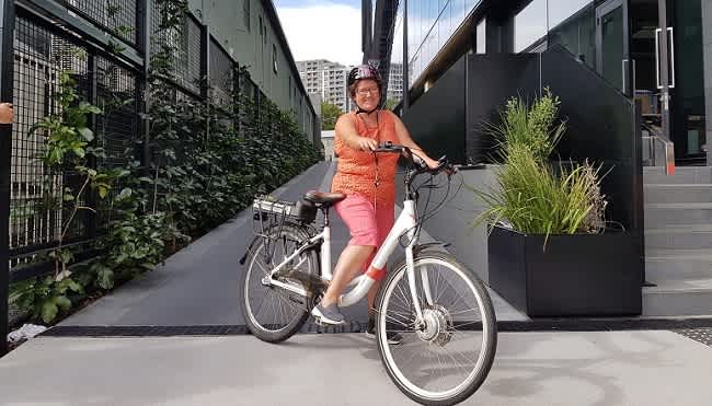 Staff member Demaris with her e-bike outside AA Insurance House in Auckland.