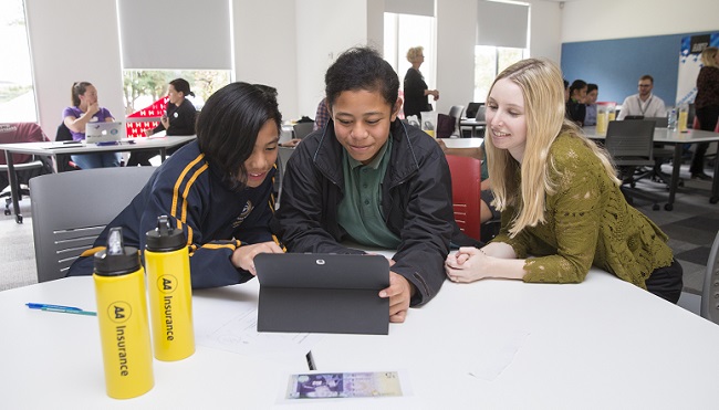 Kids look at budgeting software on a tablet