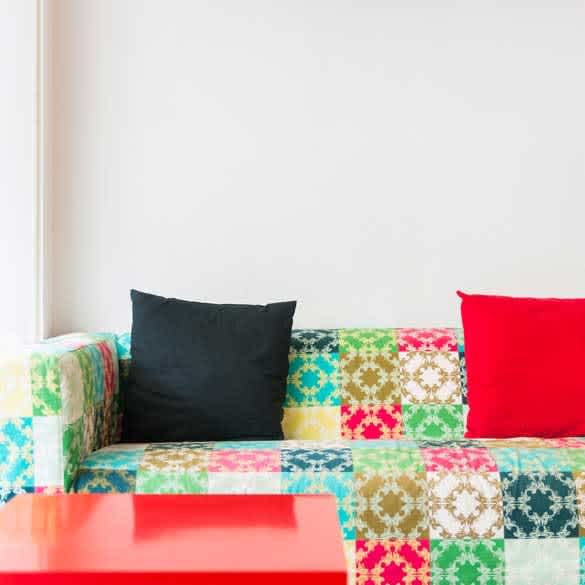 Colorful patchwork sofa with black and red cushions 