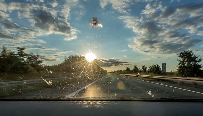 Looking through a chipped windscreen at sunset.