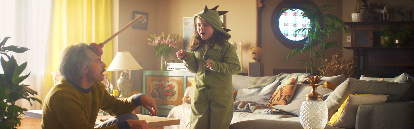 A dad and daughter playing in the living room (pretending to be a dinosaur and unicorn)