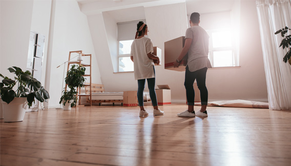 Couple setting down moving boxes in new apartment