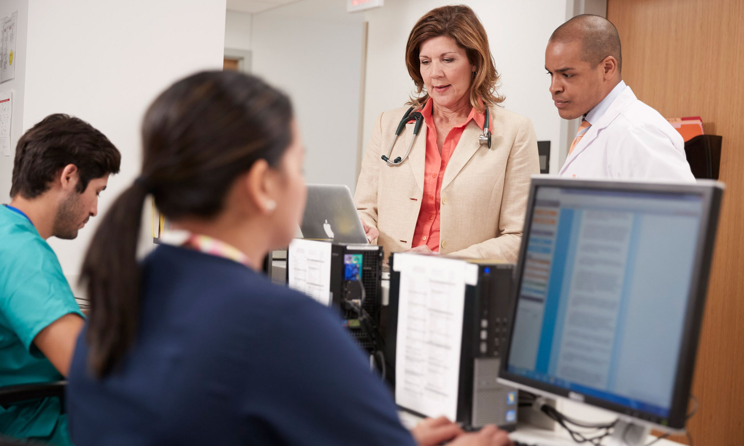 A care team gathered around a nurses station.