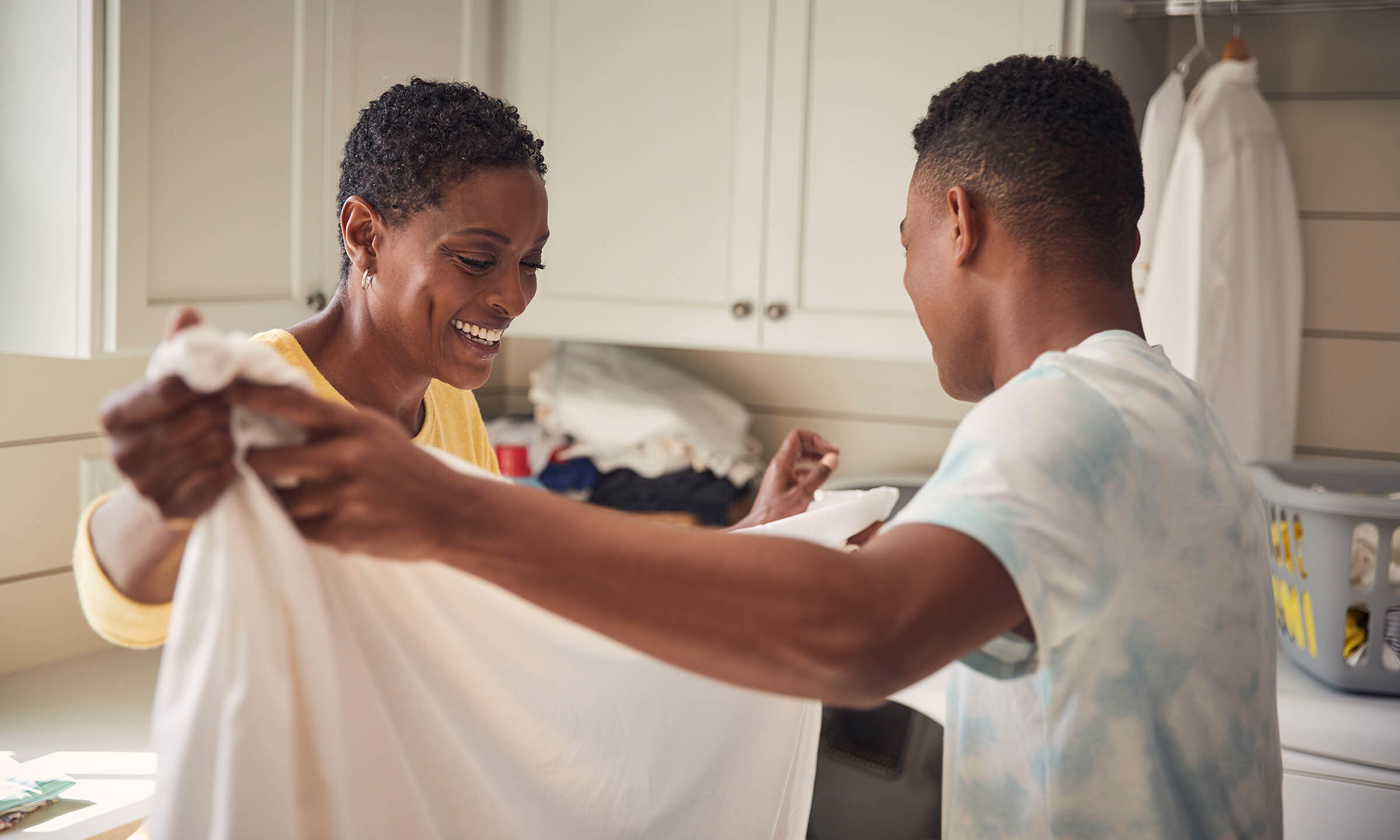 Two people folding a sheet together