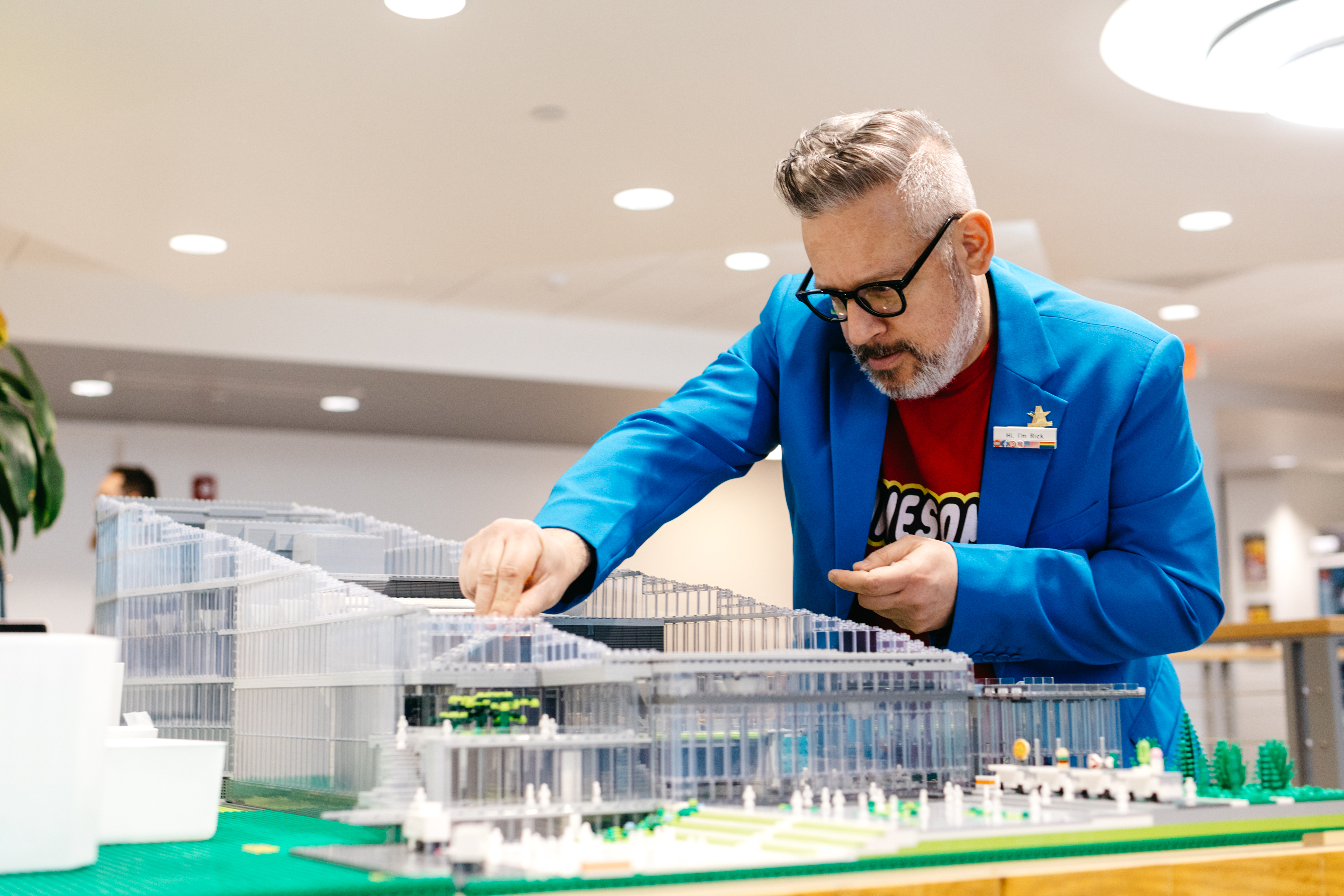 Lego Rick places a tinkers with the rendering of campus he built out of Legos. 