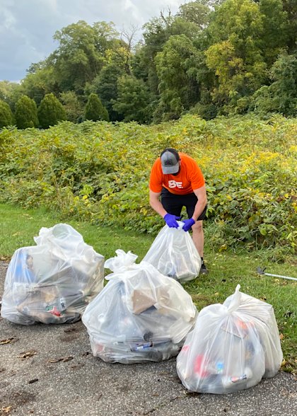 A CoverMyMeds employee picking up trash in Rhodes Park