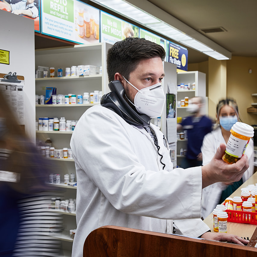 Pharmacist Greg on the phone with a bottle