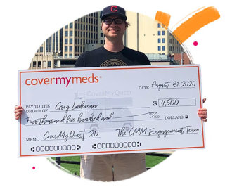 Greg poses for a photo with his quest grant check.