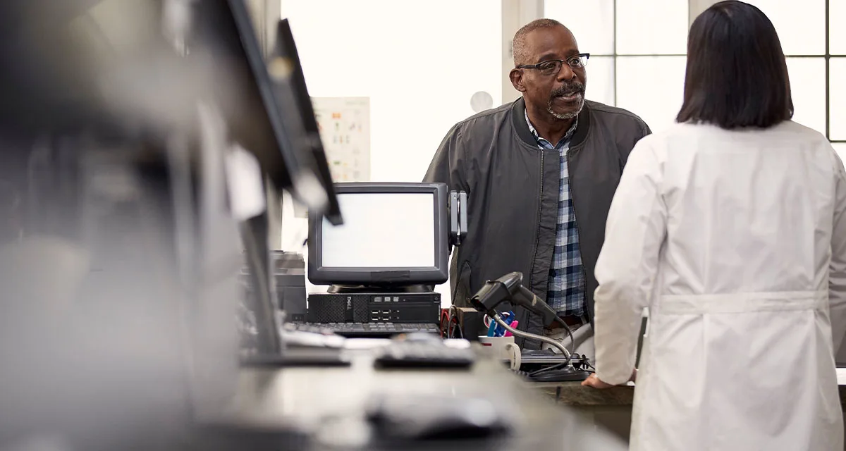 Patient chats with pharmacist at the counter