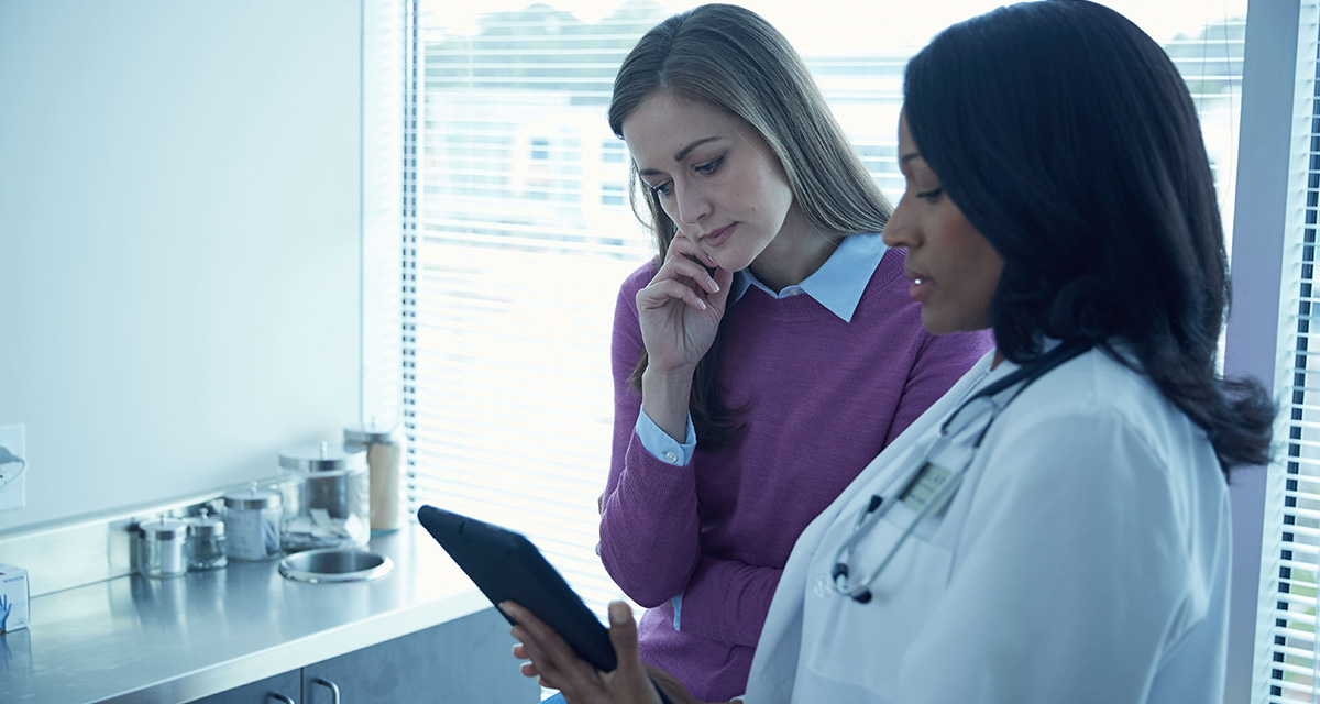 Doctor and patient consult over a tablet in an office