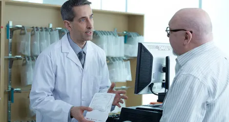 Pharmacist discusses prescription with patient.