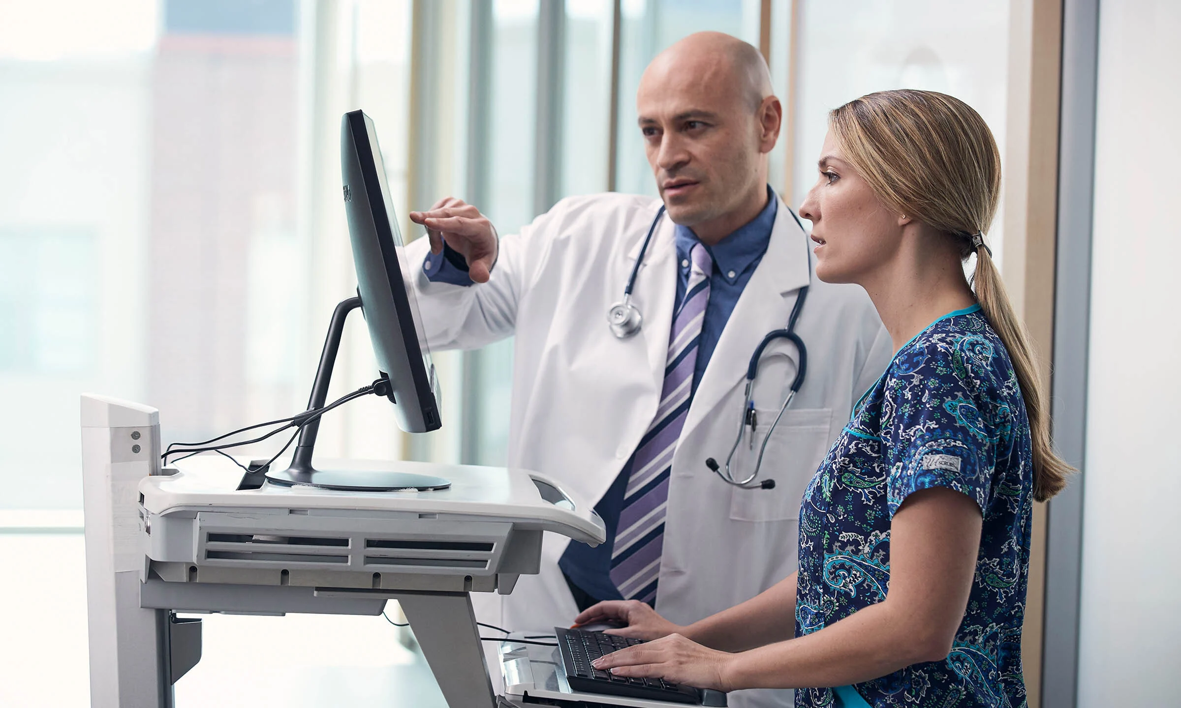 Providers discuss treatment options for a patient in front of a computer.