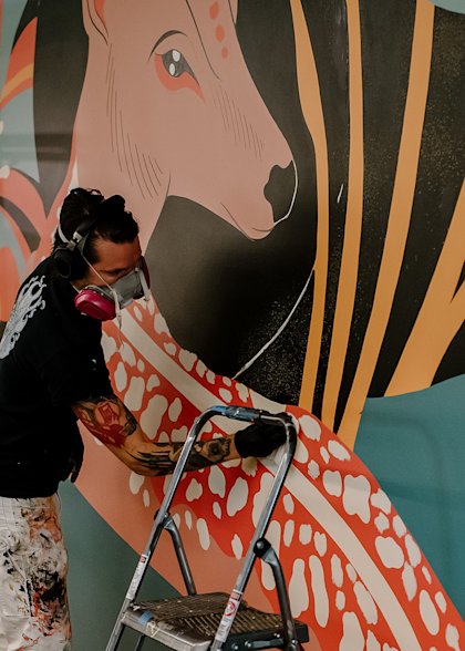 Paul works on his mural at the CoverMyMeds campus.
