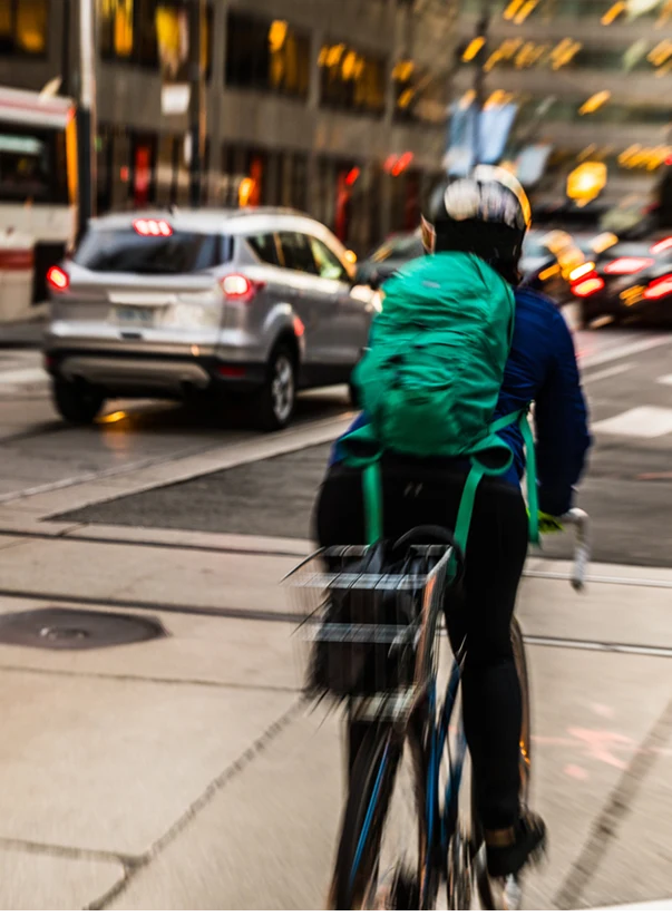 A person on a bicycle riding through city traffic