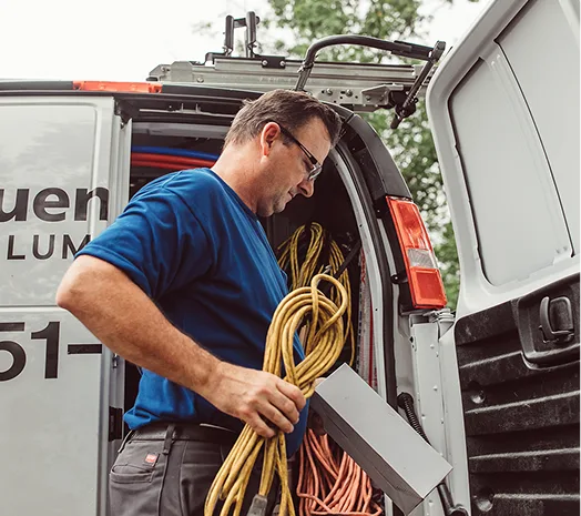 A male electrician removing a rope of wire from a work truck