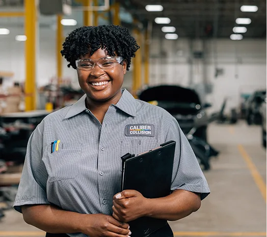 A woman holding a clipboard wearing safety glasses