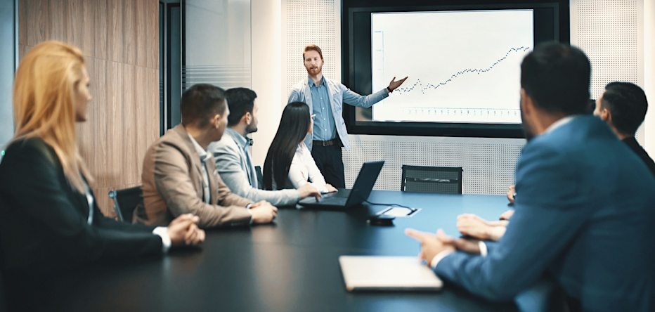 A man presenting in front of a board room
