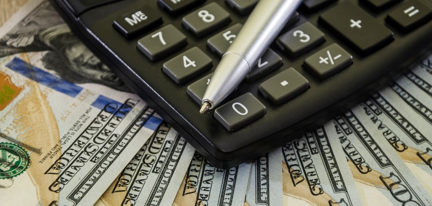 A pen resting on top of a calculator