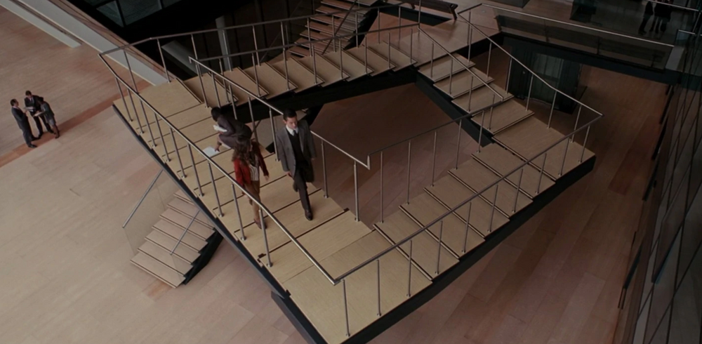 People walking and talking on a staircase that loops back to itself