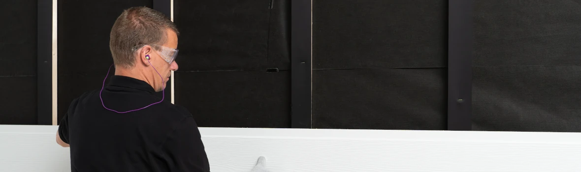 Handwerker bringt Fassadenplatten an Konstruktion am Haus an