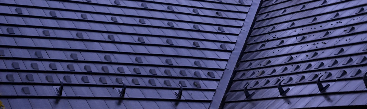 ein dunkelblaues Steildach mit Ziegeln mit Modulstützen für Solaranlage 