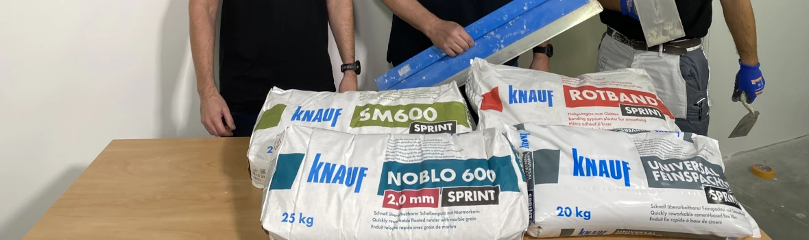 Handwerker stehen vor Säcken mit Knauf Sanierungsprodukten