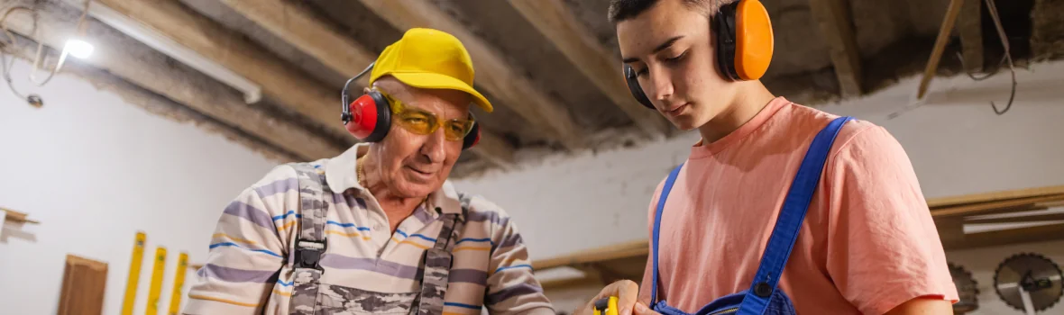 Handwerker zeigt seinem Auszubildenden etwas in der Werkstatt
