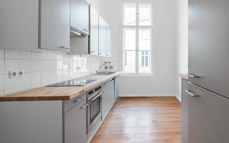 Küche mit grauen Oberflächen und weißen Wänden