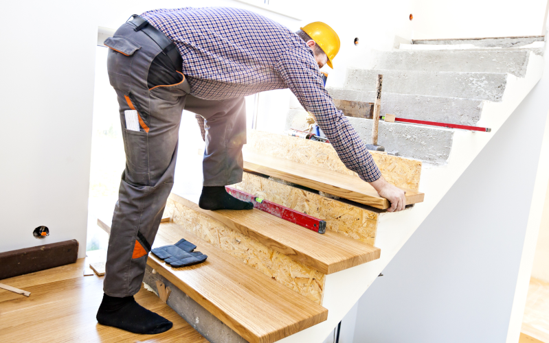Zimmerer verbaut Stufen auf einer Treppe 