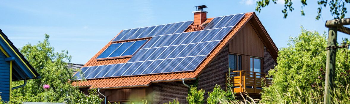 Haus mit Steildach und großer Photovoltaikanalage darauf 