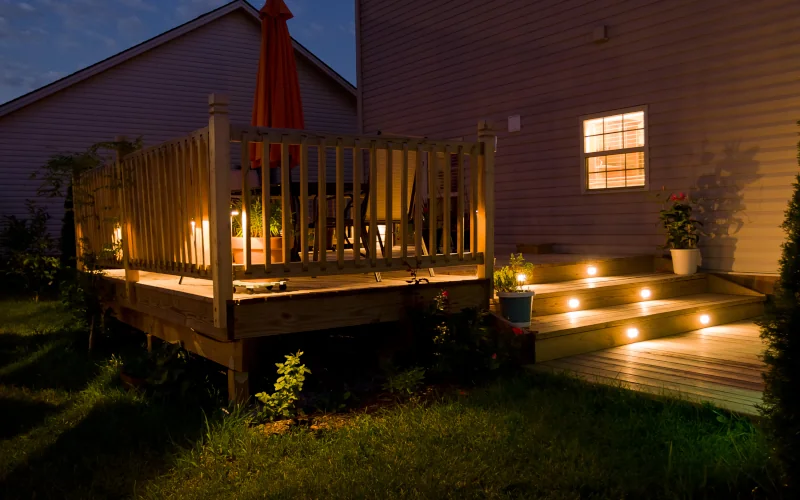 Eine beleuchtet Veranda aus Holz. 