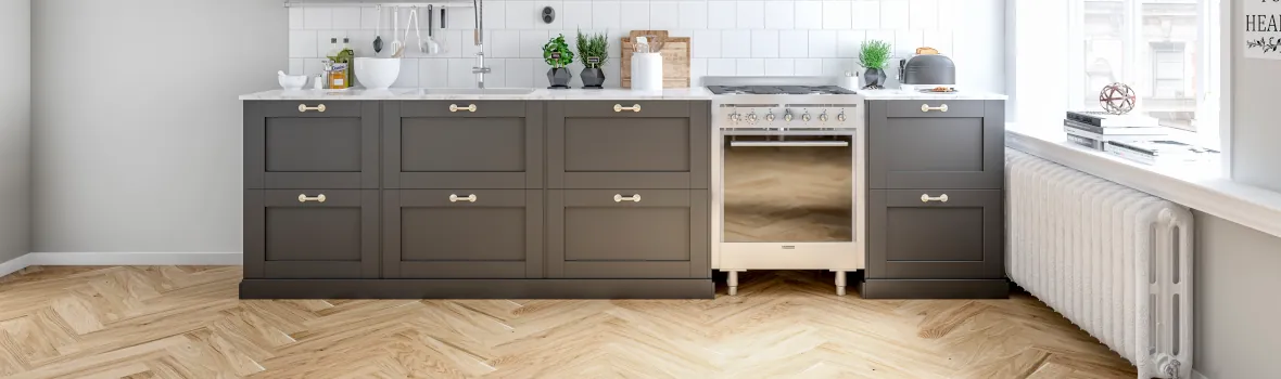 Moderne Küche mit grauen Schränken und Holzfußboden.