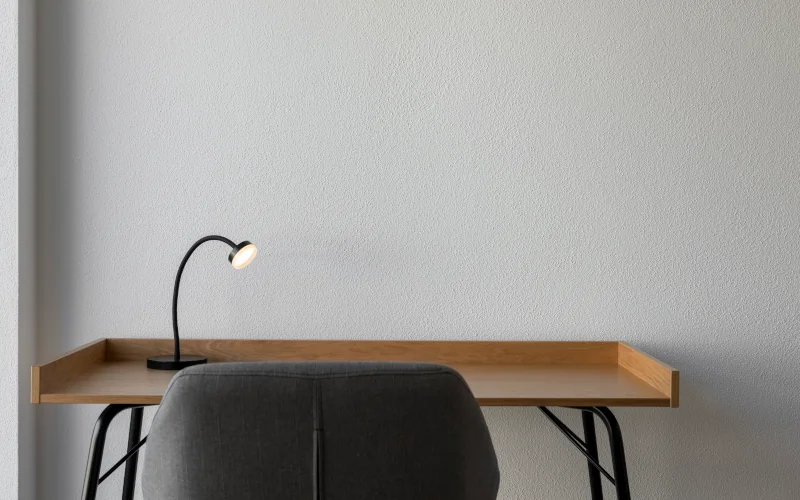 ein Raum mit einem minimalistischen Schreibtisch und Beistellstuhl