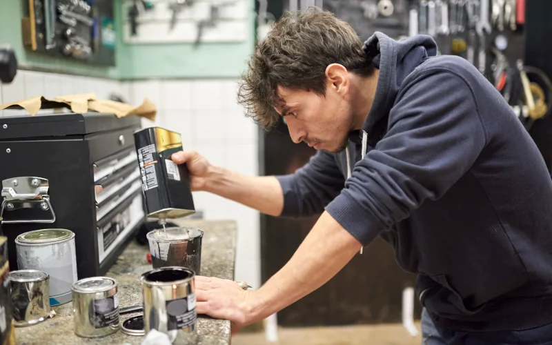 ein Handwerker mischt ein Gemisch in seiner Werkstatt an 